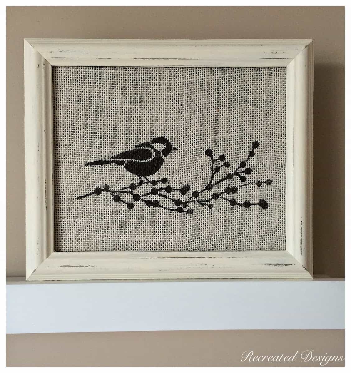 bird with a branch of berries painted on burlap in a reclaimed frame