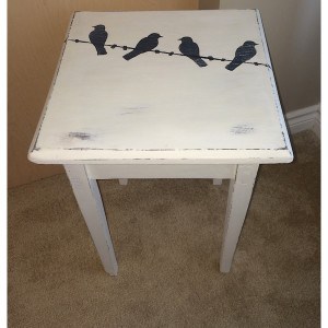 rustic table painted with four birds on a wire