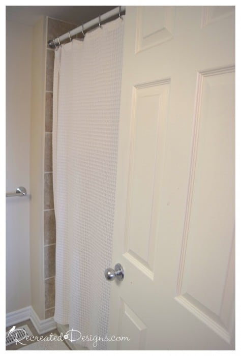 a plain white shower curtain in a bathroom