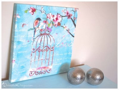 a gorgeous bird picture of blues and pinks on top of a vintage dresser