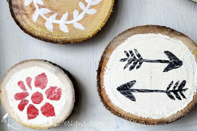 close up of wood slice magents painted with flowers and arrows