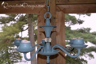 a chandelier painted with Fusion Mineral Paint with tea lights for lighting a cottage porch