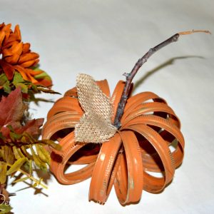 pumpkin made out of mason jar rings painted orange, twig and burlap leaves