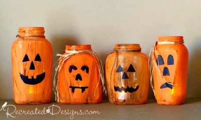 Odd shaped vintage glass jars painted like Jack-O-Lanterns with tea light inside 
