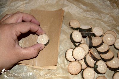 sanding small wood slices that will be used as checkers