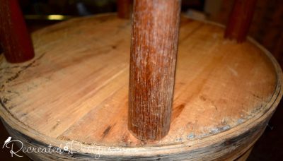 adding reclaimed wood legs to an old cheese barrel to make a side table