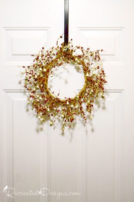 holiday wreath on a door with berries and bells