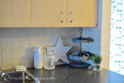 rustic star on a kitchen counter with pine needles in a glass jar