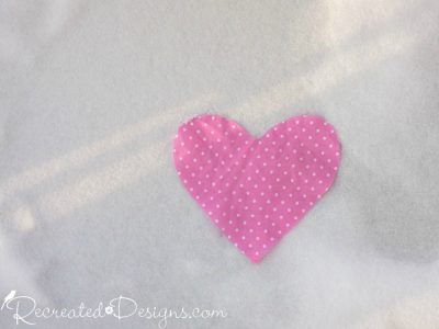 pink polka dot heart laying on snow