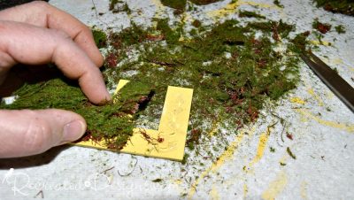 gluing moss onto yellow painted letters