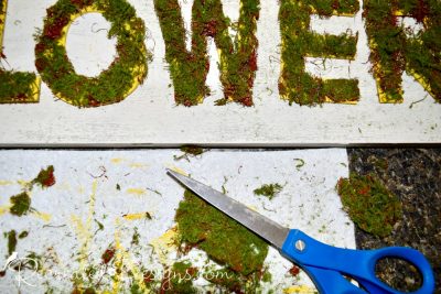 cutting moss ribbon to covered wood letters