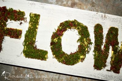 moss covered painted yellow letter on a Spring reclaimed wood sign