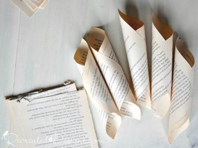 several cones out of old book pages ready to make into a paper flower