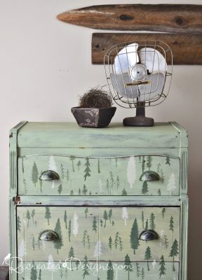 Vintage fan and antique berry box sitting on an old dresser painted green