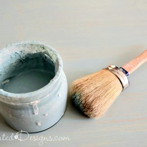 a glass jar filled with paint and a paint brush