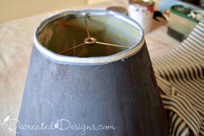 attaching a thin strip of fabric to the top of a painted lamp shade to cover the old trim