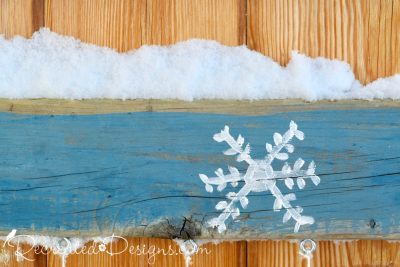 snowflake painted on reclaimed wood and snow