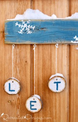 wood slices hanging from an outdoor Let it Snow sign