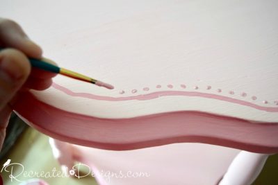 painting dots on vintage flower table with dark pink