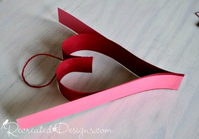 adding hearts to a paper Valentine garland by Recreated Designs