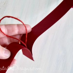 attaching a hanger to a paper heart garland by Recreated Designs