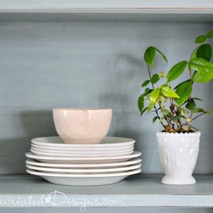white ironstone dishes with a small plant on a Farmhouse hutch