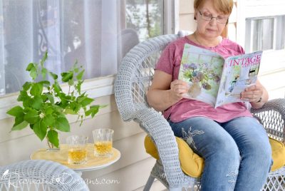 reading a magazine on a cottage porch in the summer