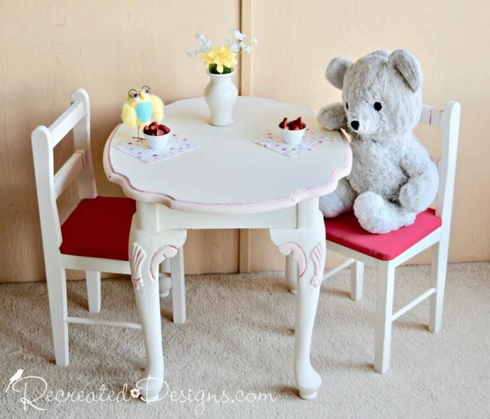 an upcycled side table and child's chairs are turned into a play set for a tea party