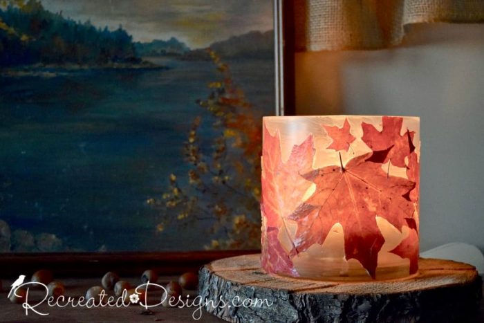 a beautiful glass candle holder covered with real Maple leaves