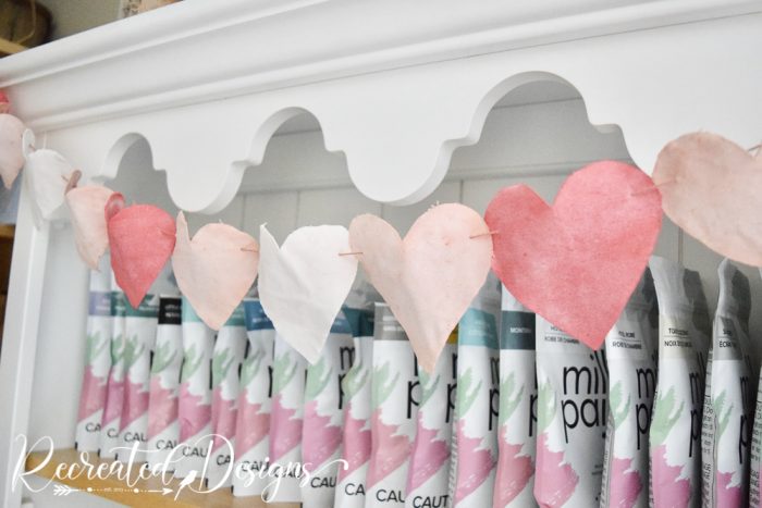 fabric hearts hanging over milk paint bags