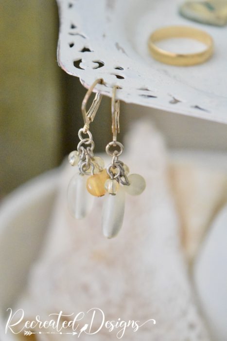 earrings hanging on a painted silver plate tray