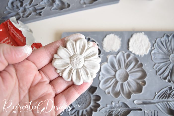 removing a clay flower from a mold