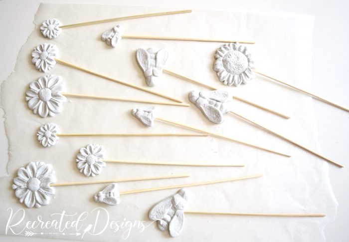 adding sticks to clay flowers and bees