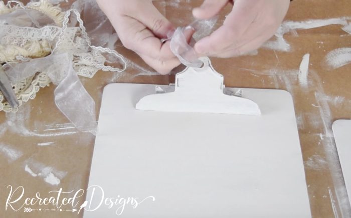 attaching a ribbon to the top of a clipboard