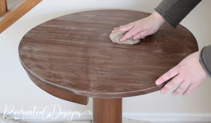 wiping a table after sanding it
