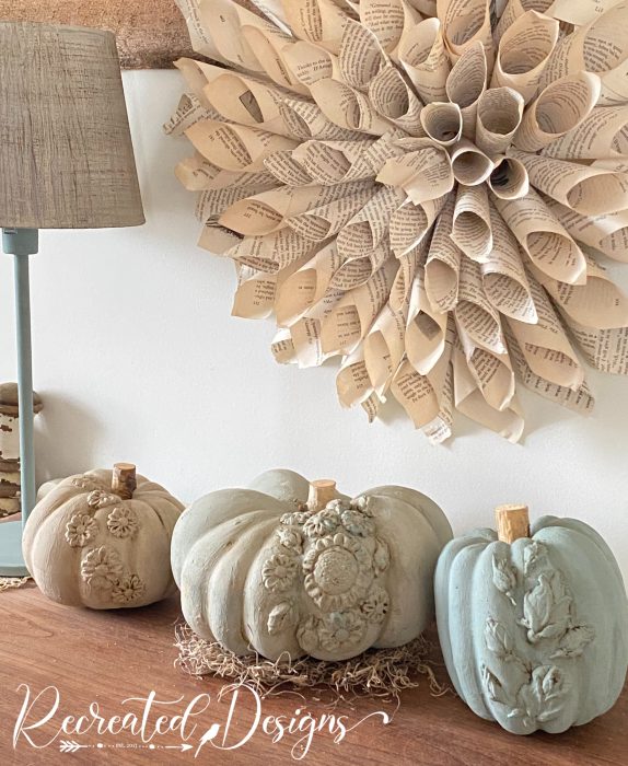 pumpkins decorated with air dry clay flowers and painted a soft muted colour 