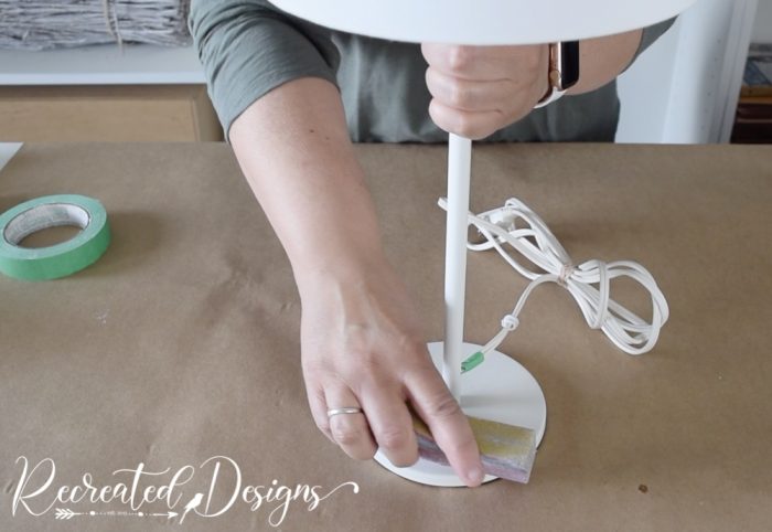 scuffing up a lamp base with a sanding block