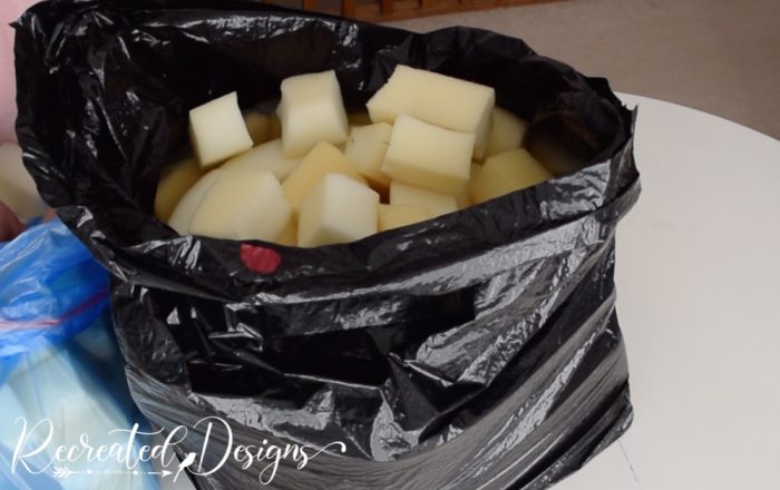 filling black garbage back with foam pieces