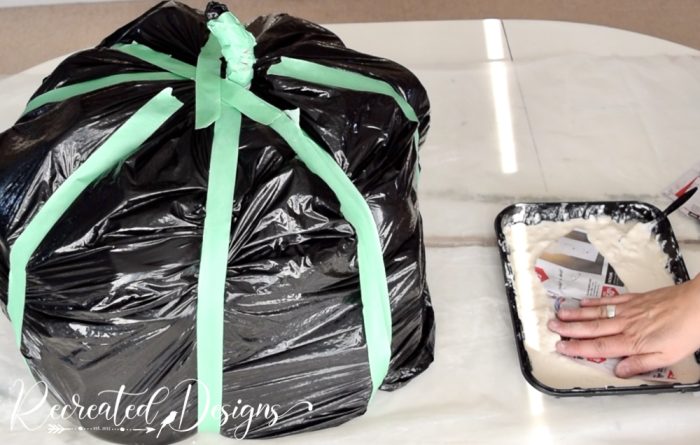 dipping newspaper into paper maché paste