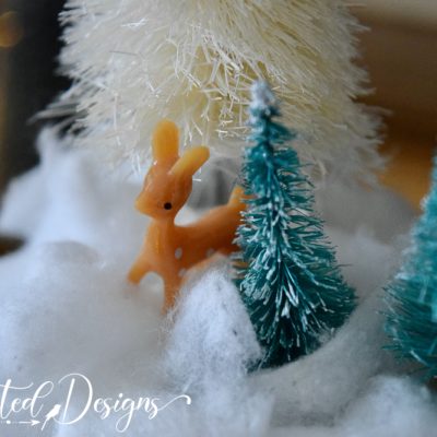 deer standing in faux cotton snow on a vintage teacup to create a magical holiday scene